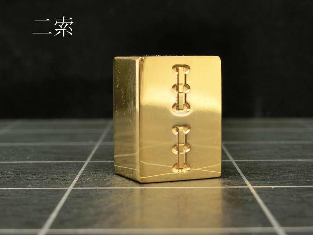 極み 削ることの極 磨き上げる極 一つひとつ職人による手作りでお届けします 24金が美しい麻雀牌 実寸大のサイズで作られた、スチールに24金メッキ加工を 施した麻雀牌です。精密加工機により実現された精巧な仕上がりで 手作業にて丁寧にっ磨き上げられるからこそ輝く光沢と 滑らかな手触りです。縁起物、インテリア、贈り物、景品としても ご利用いただけます。 牌の大きさは一般的なものと同じですが、 一般的な牌の重さが15gに対して、極みの牌の重さは50gです。 金属ならではの重厚感をお楽しみいただけます。 洗練されたデザインの化粧箱付きです。 購入後、そのままプレゼントしていただけます。 愛好家の方や、ちょっと変わったものが好きな方へのギフトとして おすすめです。大会の景品としても人気です。 高級感のあるインテリアとしてお楽しみいただけます。