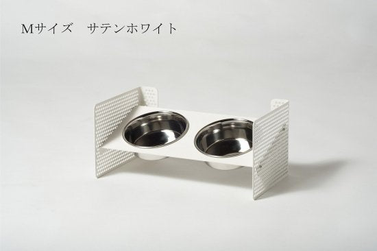 側板のネジ穴の位置を変えることで、台の高さや角度を 変えられます。ペットの体に合わせられるので、ストレスのない食事を可能にします。 組立式食器スタンド この商品は、側面のパンチングメタルの穴位置を変えることで、 高さや角度が自由に調整できます。 ペットの体に合わせた位置に調整して、ストレスなく食事をすることが可能です。 購入後に高さが合わないという失敗や、食事の勢いで食器がズレる・ひっくり返してしまう といった悩みをクリアできます。 首を下げて食事をする姿勢は、実は大きなリスクがあるのをご存じでしたか? むせやすいだけでなく、誤飲や肺炎、胃捻転を引き起こす恐れもあります。 できるだけそうしたリスクを取り除き、 ストレスなく食べさせてあげるために、ペットの体に合った食器台を選ぶことが 大切です。