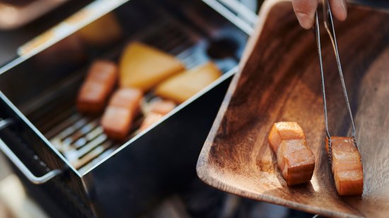 +Baseは網焼・串焼・鉄板焼・鍋・蒸し・燻製・熱燗ができるオールインワン 炭焼き器です。機能性やデザイン性を評価いただけ、 東京インターナショナル・ギフト・ショー春2022のコンテストでは新製品コンテスト 準大賞受賞を果たしました。+Baseがあればキャンプ料理は無限大。 キャンプで最高のパフォーマンスを発揮できるよう細部にまでこだわりました。 1.調理しやすい 上長辺に凹凸をつけ、串や網、鍋を固定できる。 2.安全で簡単 鍋の取手を本体に安定させて、安全に簡単にキャンプ料理を楽しめます。 3.傷の防止 木の敷板の上に置くことで、テーブルへのダメージを防ぐ。 4.洗いやすい 炭箱・ロストル(炭を設置する台)を簡単に分解して丸洗い可能。 5.扱いやすい 野燗炉蓋を外さなくても水追加が可能。 オーバーフロー穴で水溢れを防ぐ。 コンパクト!抜群の収納性! オプション品の手持ちハンドルや 収納バッグを併用することで、荷物の多いキャンプでの持ち運びも便利です。 本体は汚れる心配が多いキャンプにおいても汚れにも強い耐熱黒塗装と クールな無塗装仕上げの2タイプです。お好みでお選びください。