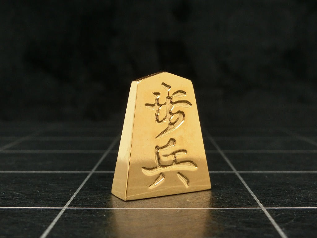 極み 削ることの極 磨き上げる極 一つひとつ職人による手作りでお届けします 24金が美しい将棋駒 実寸大のサイズで作られた、スチールに24金メッキ加工を 施した将棋駒です。精密加工機により実現された精巧な仕上がりで 手作業にて丁寧にっ磨き上げられるからこそ輝く光沢と 滑らかな手触りです。縁起物、インテリア、贈り物、景品としても ご利用いただけます。 駒の大きさは一般的なものと同じですが、 王将の大きさですと35gの重さがあります。 金属ならではの重厚感をお楽しみいただけます。 洗練されたデザインの化粧箱付きです。 購入後、そのままプレゼントしていただけます。 愛好家の方や、ちょっと変わったものが好きな方へのギフトとして おすすめです。大会の景品としても人気です。 高級感のあるインテリアとしてお楽しみいただけます。 # 藤井聡太 さん # 藤井聡太竜王名人 #藤井聡太八冠