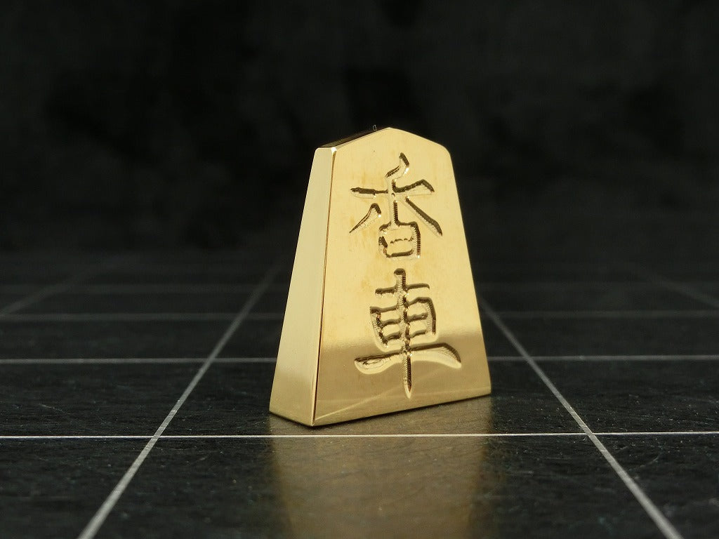 極み 削ることの極 磨き上げる極 一つひとつ職人による手作りでお届けします 24金が美しい将棋駒 実寸大のサイズで作られた、スチールに24金メッキ加工を 施した将棋駒です。精密加工機により実現された精巧な仕上がりで 手作業にて丁寧にっ磨き上げられるからこそ輝く光沢と 滑らかな手触りです。縁起物、インテリア、贈り物、景品としても ご利用いただけます。 駒の大きさは一般的なものと同じですが、 王将の大きさですと35gの重さがあります。 金属ならではの重厚感をお楽しみいただけます。 洗練されたデザインの化粧箱付きです。 購入後、そのままプレゼントしていただけます。 愛好家の方や、ちょっと変わったものが好きな方へのギフトとして おすすめです。大会の景品としても人気です。 高級感のあるインテリアとしてお楽しみいただけます。 # 藤井聡太 さん # 藤井聡太竜王名人 # 藤井聡太八冠